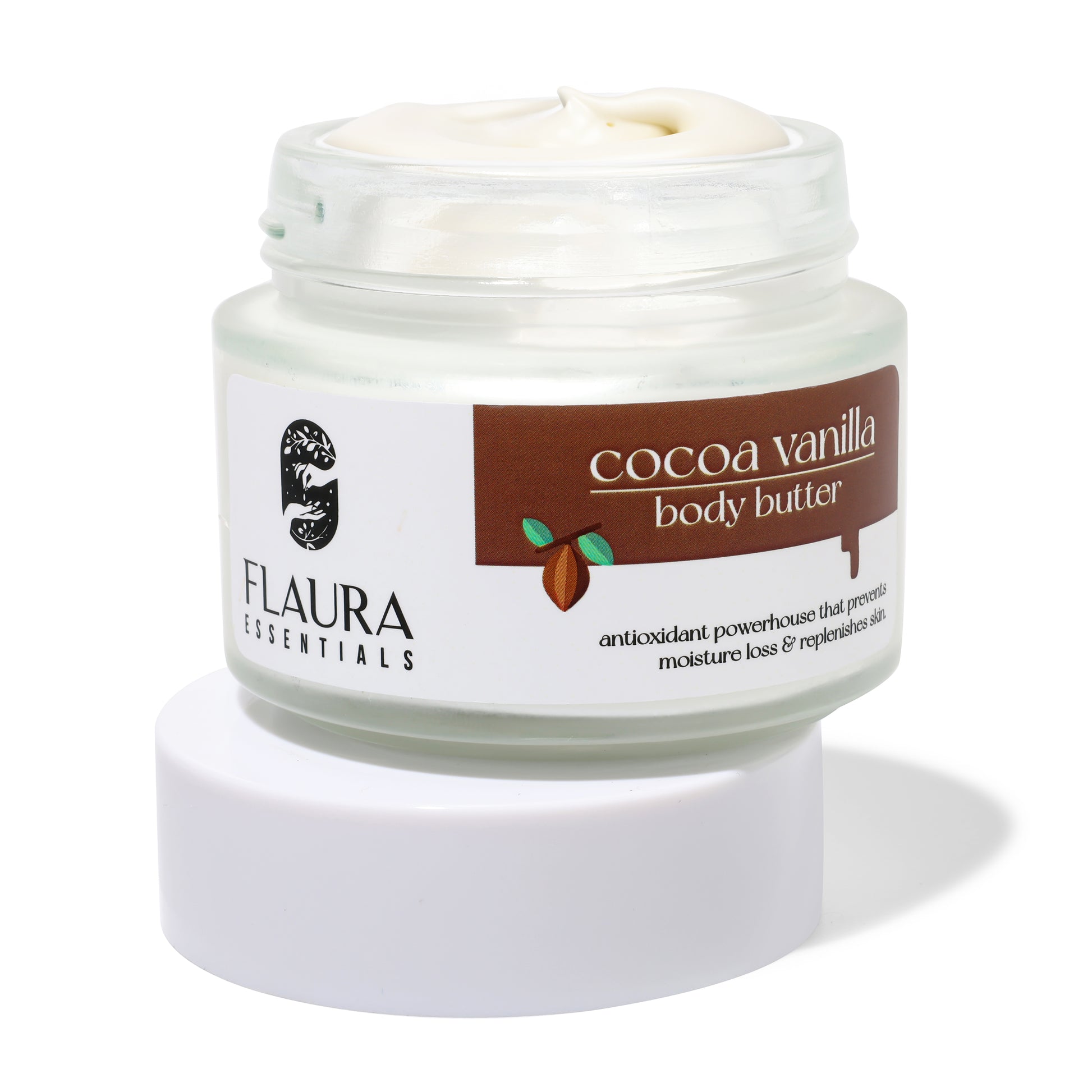 A jar of Flaura Essentials Caffeine High Coffee Face Scrub with the lid off, revealing its creamy texture. The label displays coffee bean graphics and text highlighting it as an antioxidant-rich powerhouse that prevents moisture loss and revitalizes the skin.